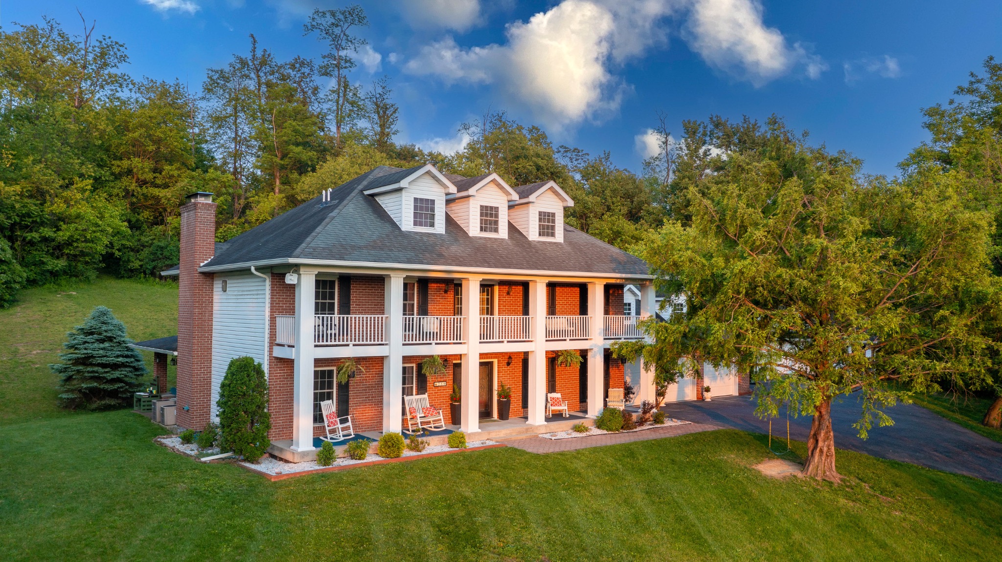 Aerial view of a two-story brick home and landscaped lawn