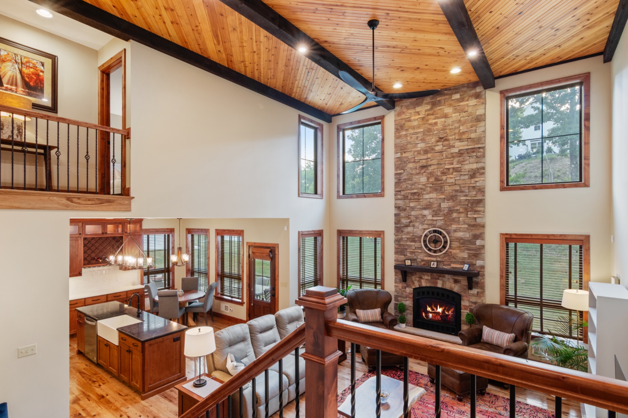 Two-story great room with stone fireplace and exposed wood ceiling