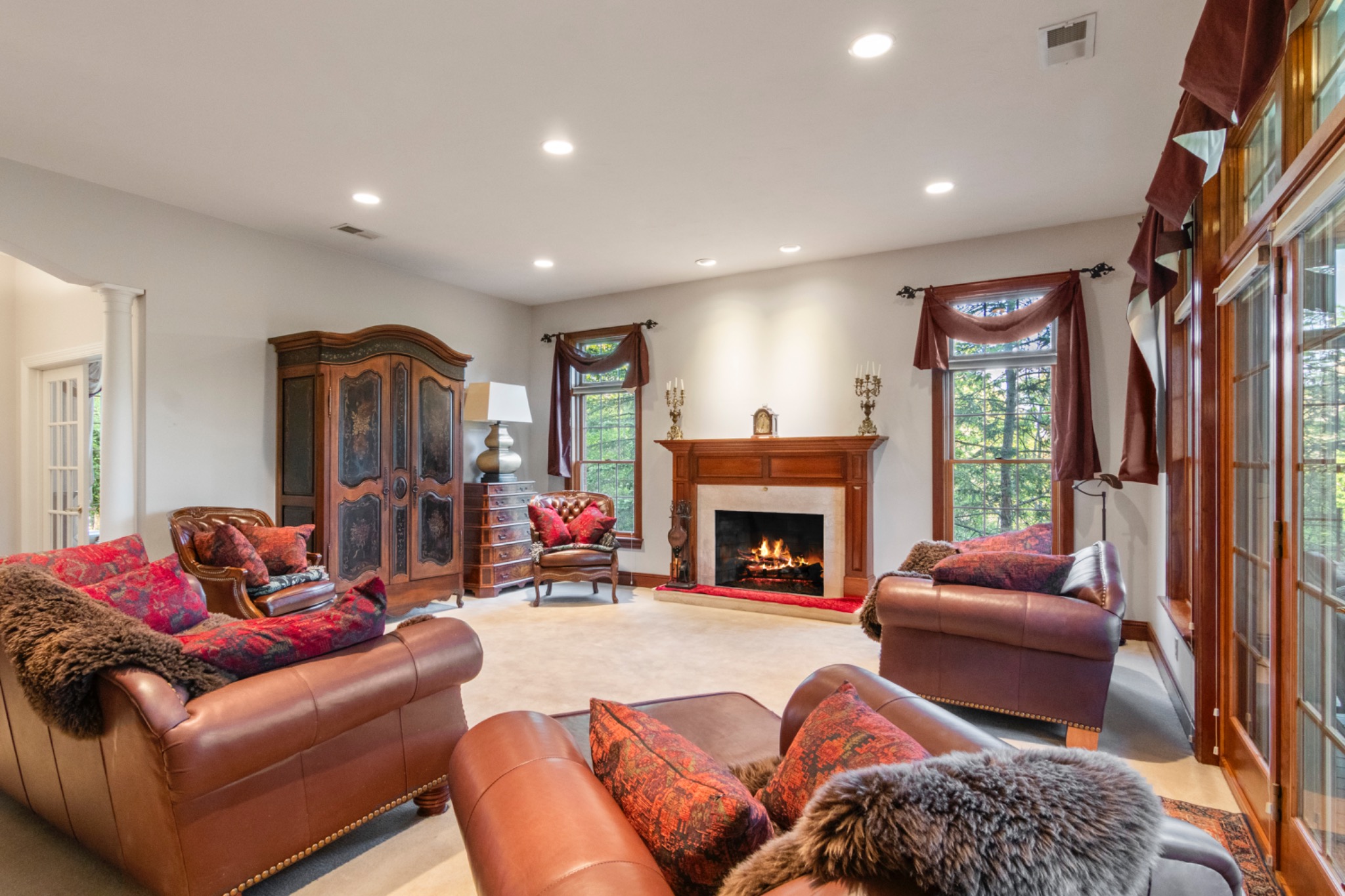 Second view of a living room with fireplace and tall windows