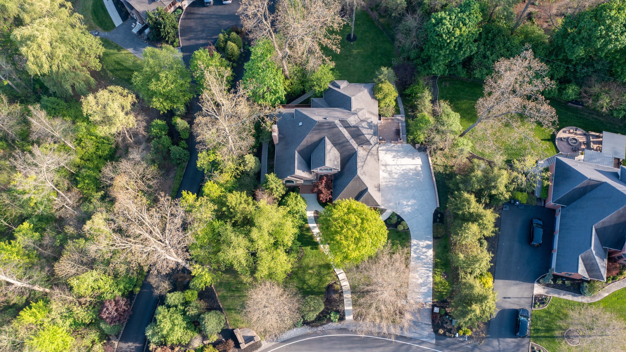 Overhead drone view of a home and wooded grounds
